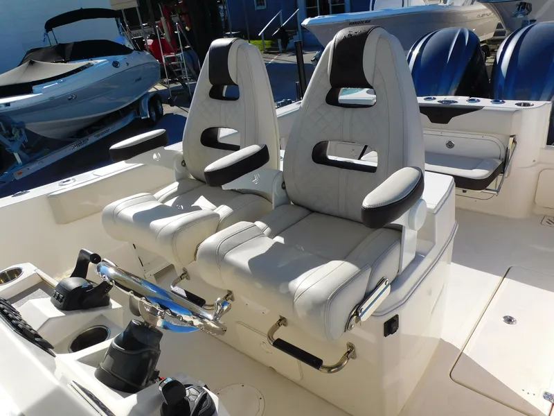 Slide: The Image of 2023 Sailfish 290 CC boat with dual captain's chairs and modern helm controls. - 11