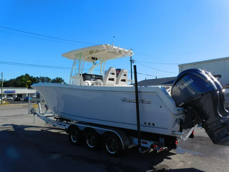 Slide: The Image of 2023 Sailfish 290 CC boat on trailer with Yamaha engine, parked outdoors. - 3