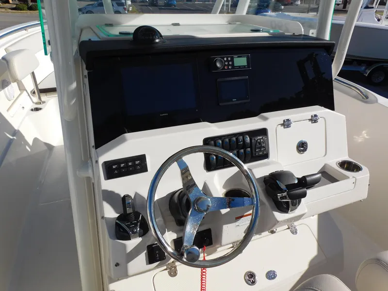 Slide: The Image of 2023 Sailfish 290 CC boat dashboard with steering wheel and control panel. - 6