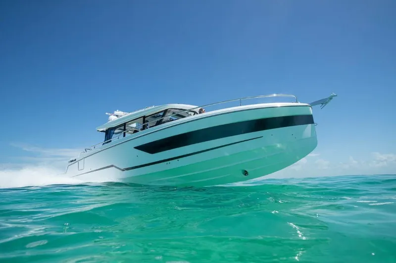 Slide: The Image of 2025 Wellcraft 38 Explorer cruising on clear turquoise water under a bright blue sky. - 2