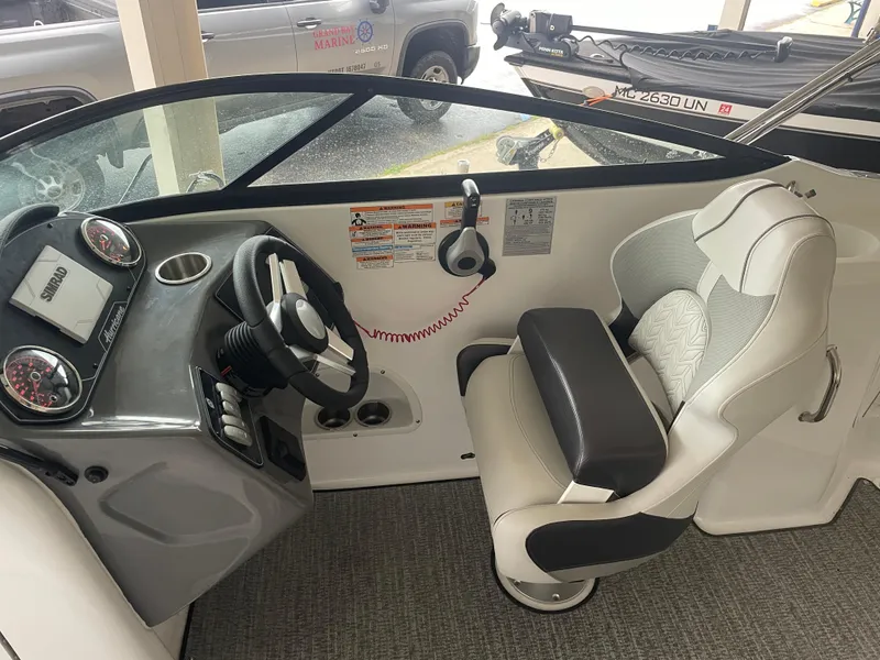 Slide: The Image of 2022 Hurricane SunDeck 2200 DC OB boat interior with steering wheel and captain's chair. - 8