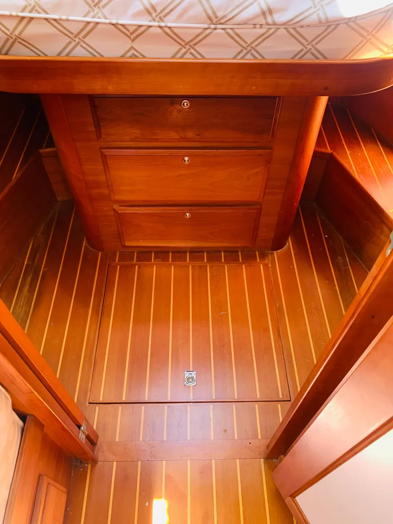Slide: The Image of 2004 Sabre 42 Hardtop Express cabin with wooden flooring and storage drawers. - 10