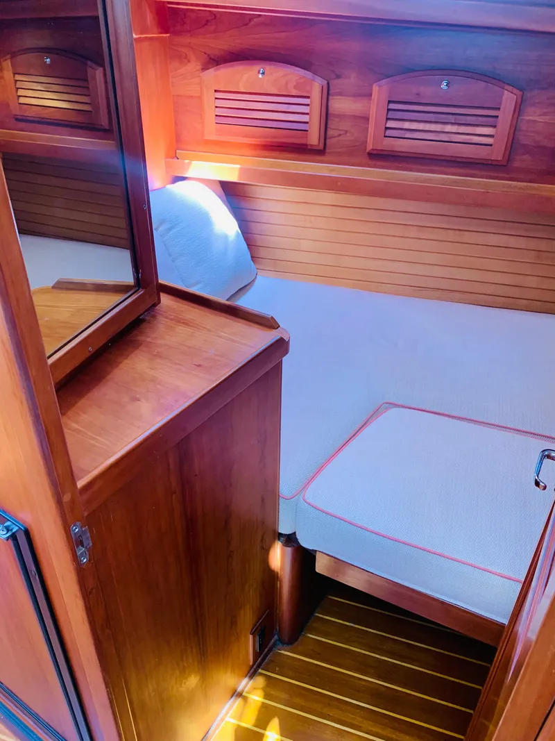 Slide: The Image of 2004 Sabre 42 Hardtop Express cabin with wooden interior and cozy bed. - 11