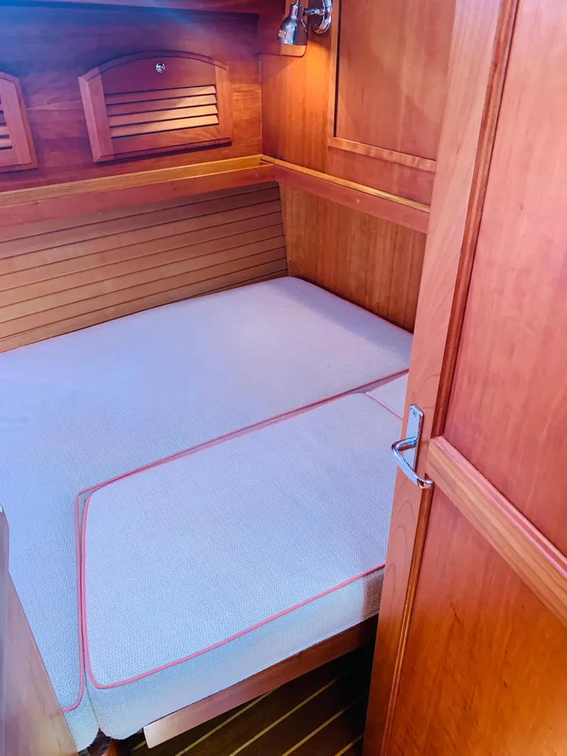 Slide: The Image of 2004 Sabre 42 Hardtop Express cabin with wooden interior and cozy bed. - 12