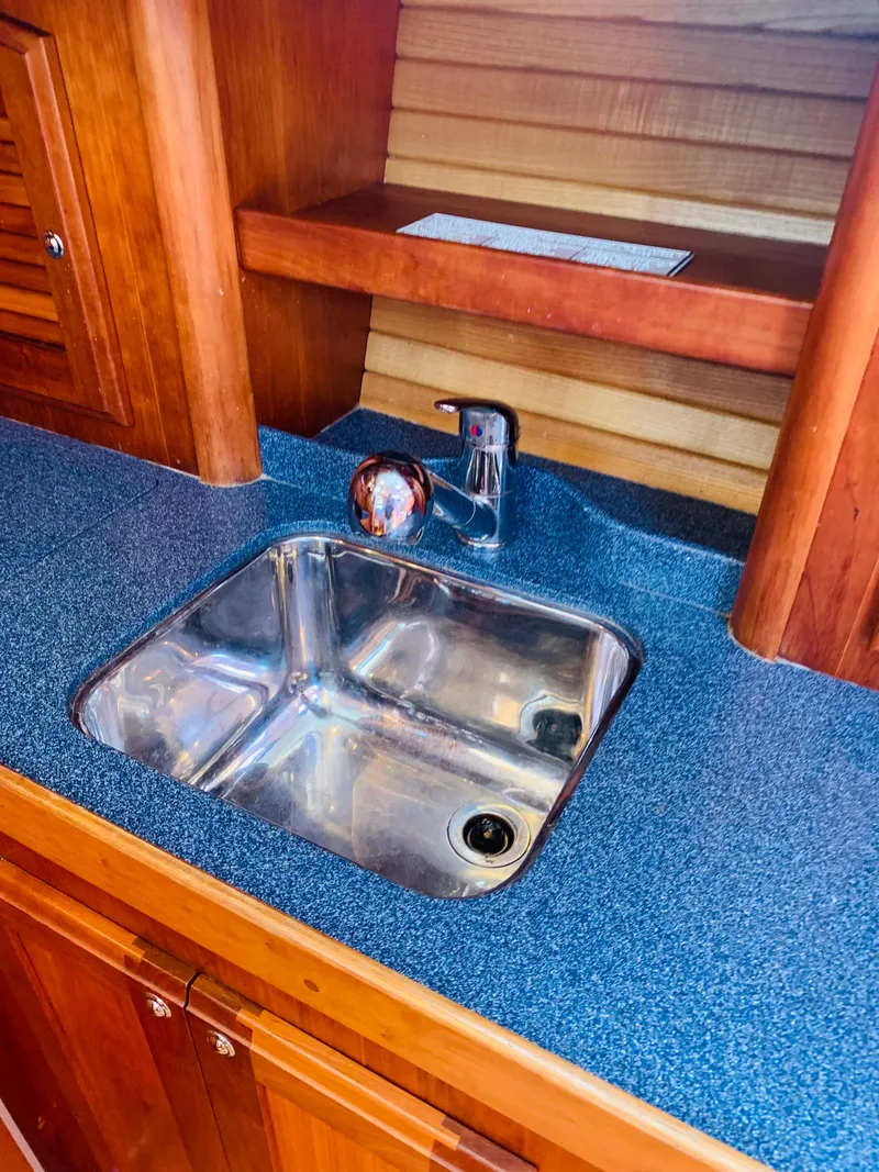 Slide: The Image of 2004 Sabre 42 Hardtop Express yacht interior with stainless steel sink and wooden cabinetry. - 14