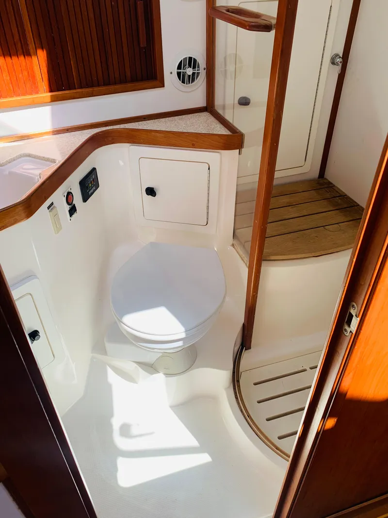 Slide: The Image of 2004 Sabre 42 Hardtop Express yacht bathroom with modern fixtures and wooden accents. - 15