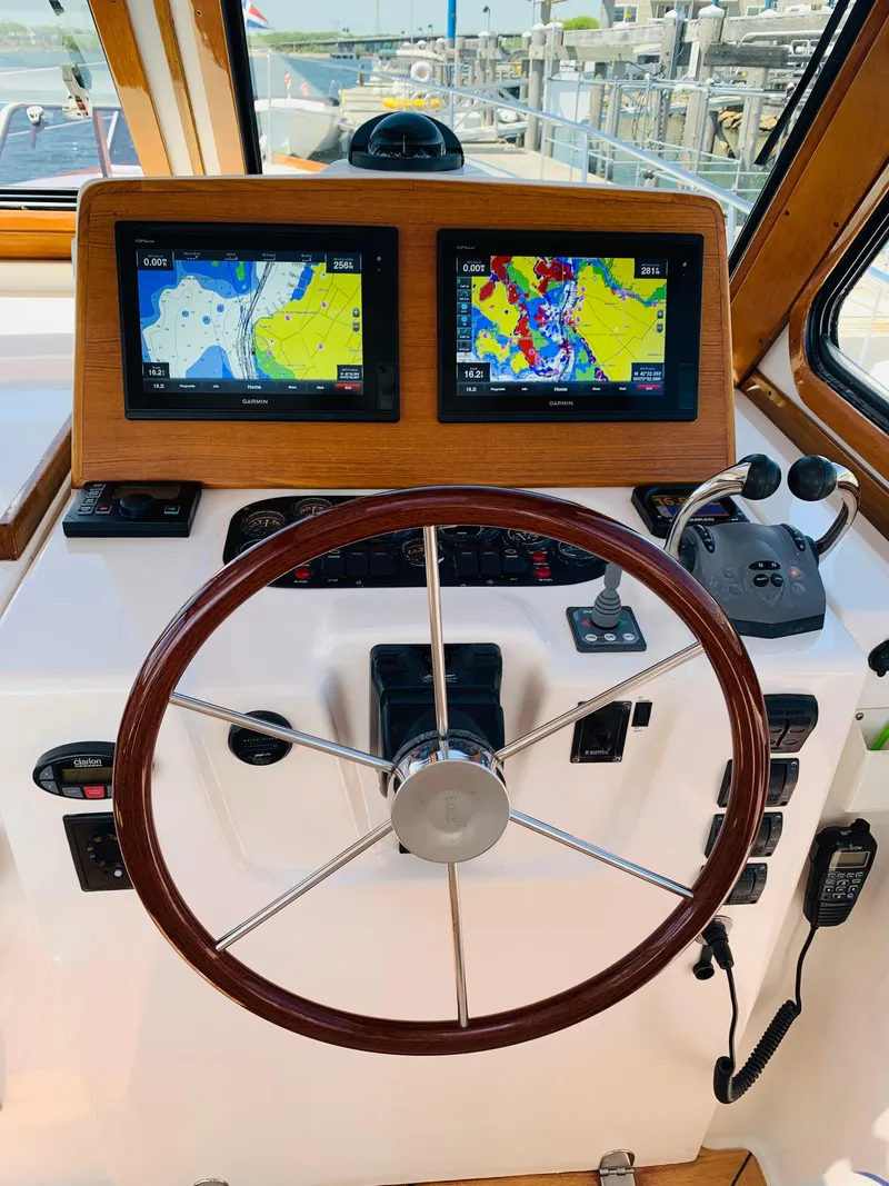 Slide: The Image of 2004 Sabre 42 Hardtop Express helm with dual navigation screens and wooden steering wheel. - 18