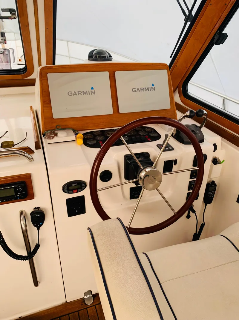 Slide: The Image of 2004 Sabre 42 Hardtop Express helm with Garmin navigation displays and wooden steering wheel. - 19