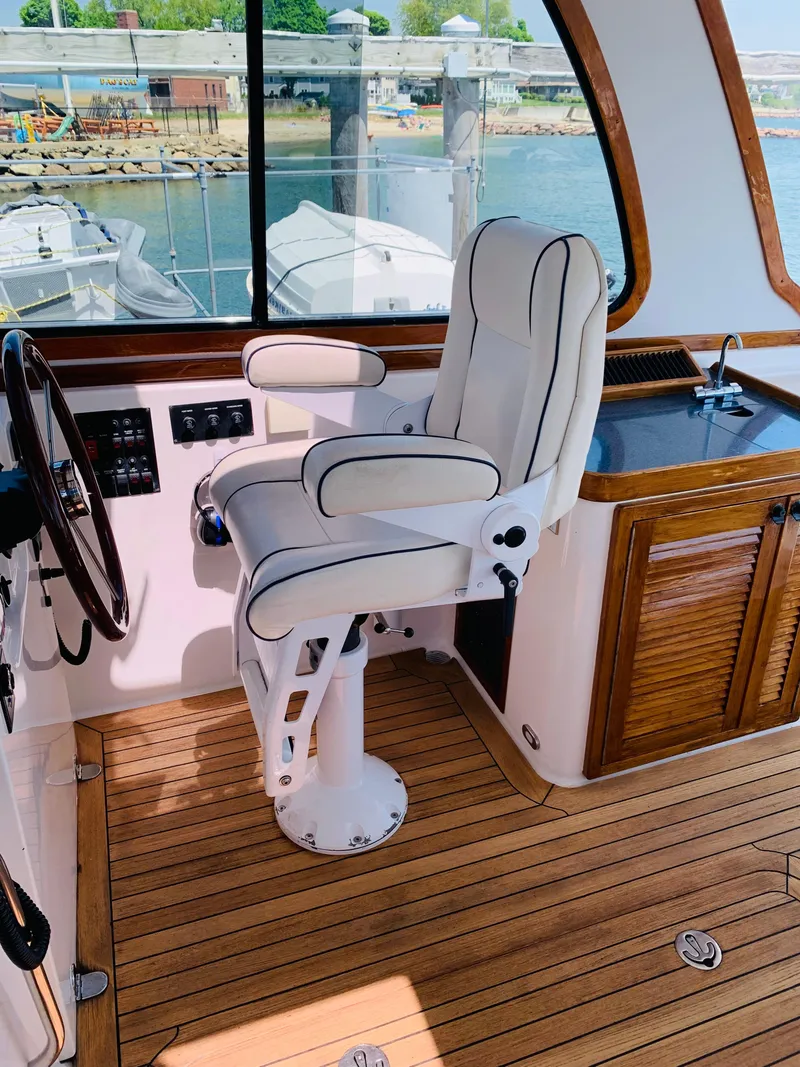 Slide: The Image of 2004 Sabre 42 Hardtop Express helm with white captain's chair and wooden interior. - 24