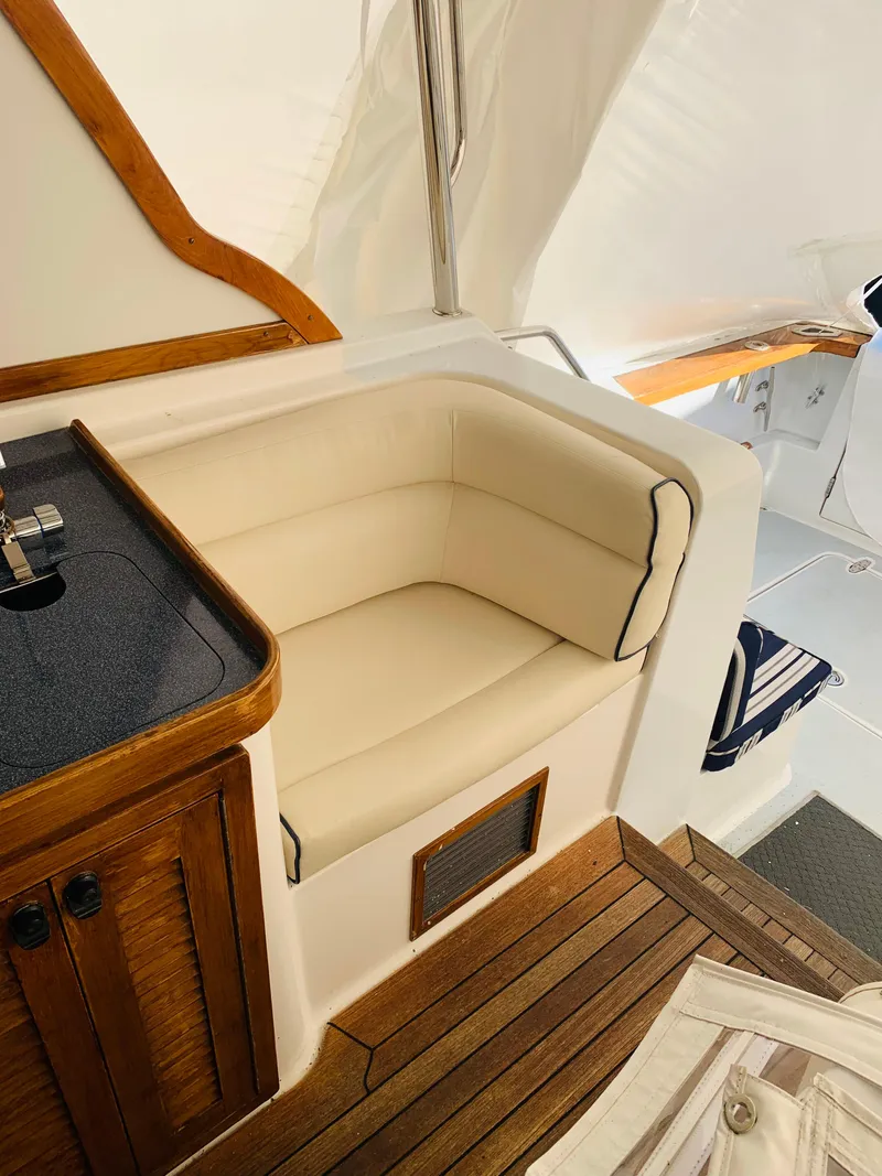 Slide: The Image of 2004 Sabre 42 Hardtop Express interior with cushioned seating and wooden accents. - 29