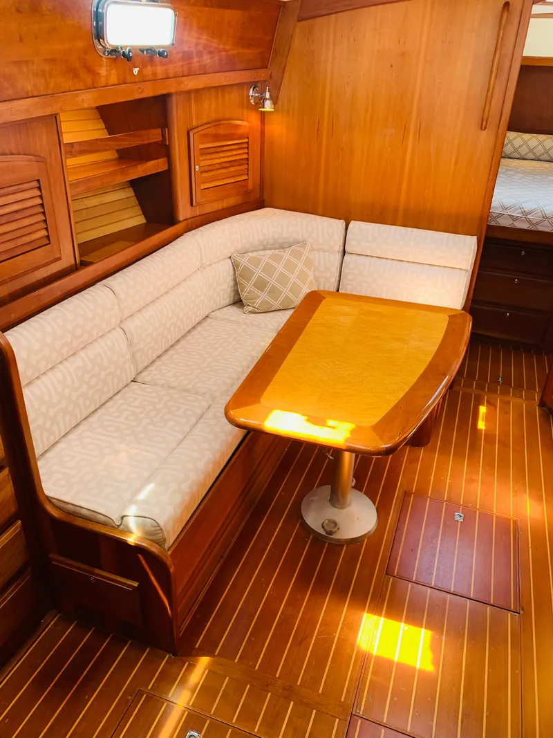 Slide: The Image of 2004 Sabre 42 Hardtop Express interior with wooden dining area and cushioned seating. - 3