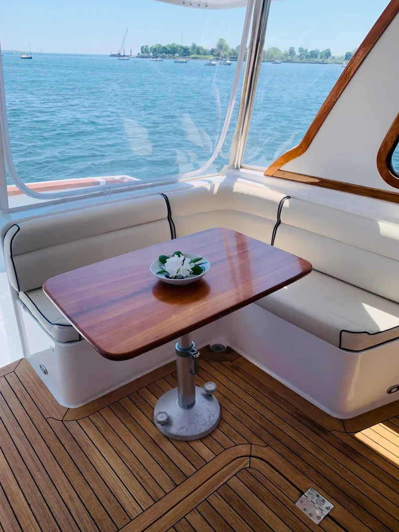 Slide: The Image of 2004 Sabre 42 Hardtop Express interior with wooden table and scenic ocean view. - 30
