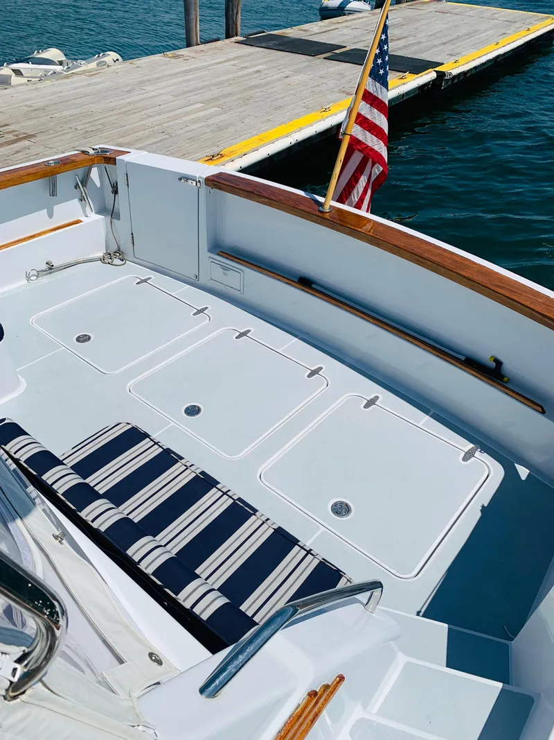 Slide: The Image of 2004 Sabre 42 Hardtop Express boat with striped seating, docked by the water. - 34