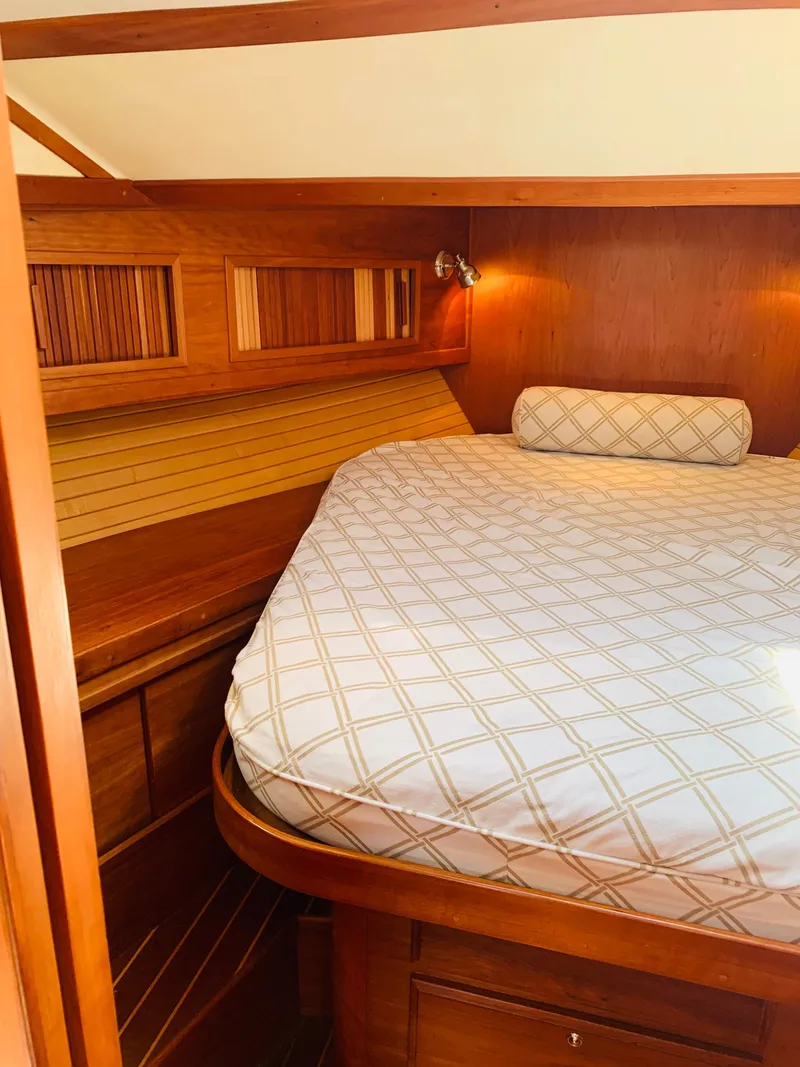 Slide: The Image of 2004 Sabre 42 Hardtop Express cabin with wooden interior and cozy bed. - 6