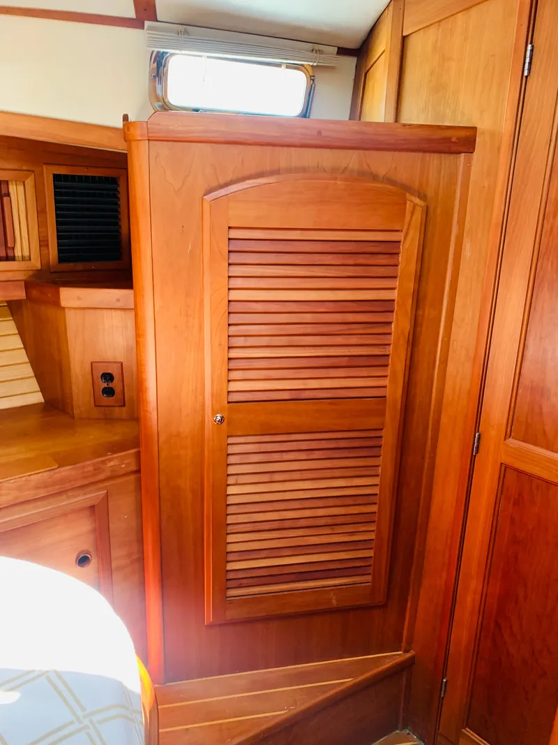 Slide: The Image of 2004 Sabre 42 Hardtop Express interior with wooden cabinetry and window. - 8