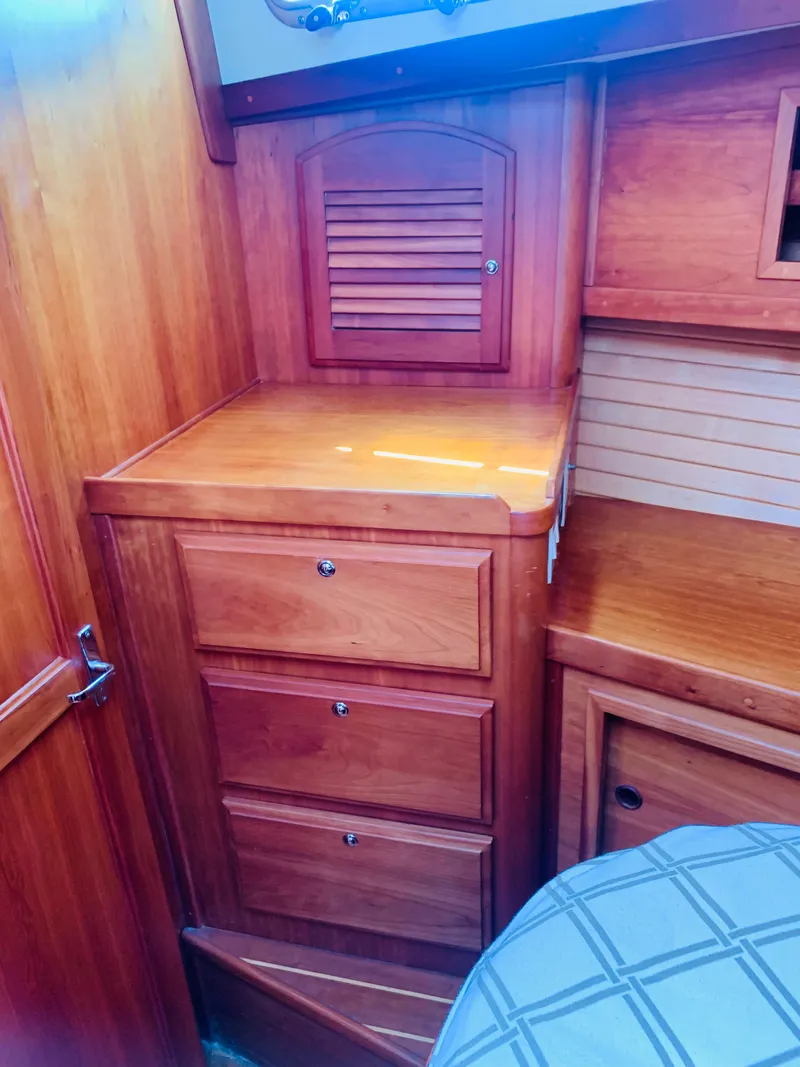Slide: The Image of 2004 Sabre 42 Hardtop Express interior with wooden cabinetry and drawers. - 9