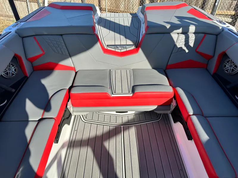 Slide: The Image of 2022 Nautique S23 boat interior with gray and red seating, modern design. - 14