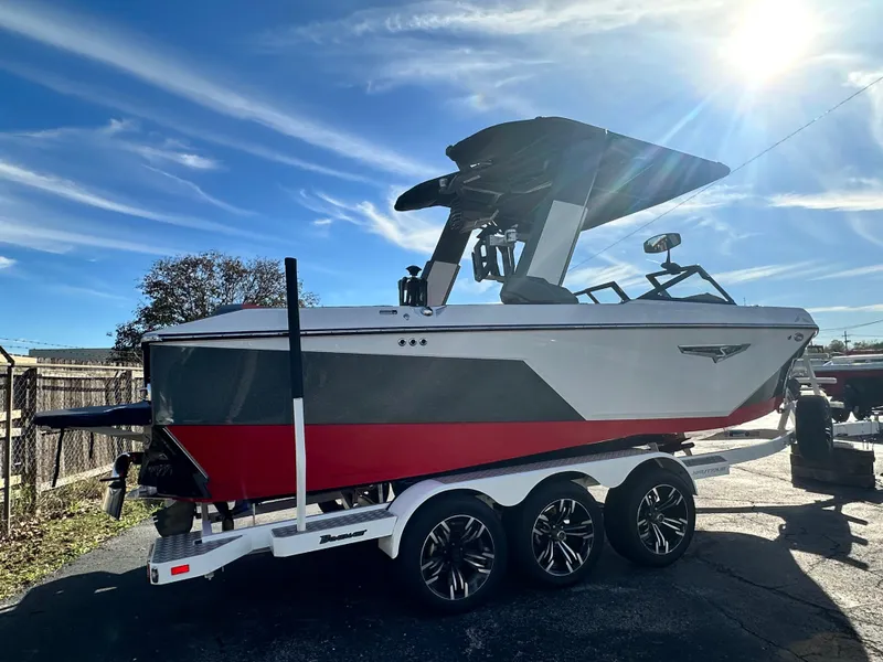 Slide: The Image of 2022 Nautique S23 boat on trailer under sunny sky. - 5
