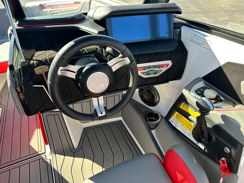 Slide: The Image of 2022 Nautique S23 boat dashboard with steering wheel and control panel. - 8