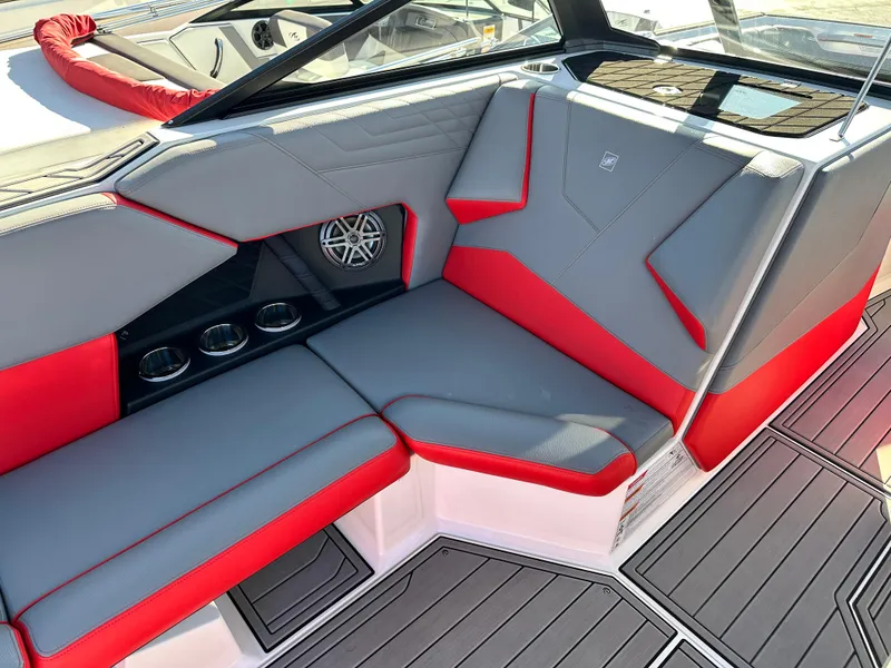 Slide: The Image of 2022 Nautique S23 boat interior with red and gray seating and cup holders. - 9