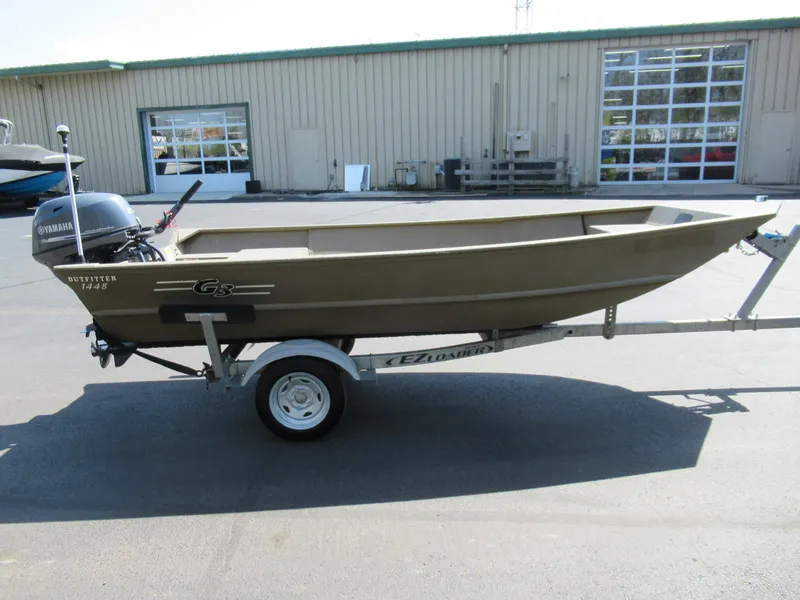 Slide: The Image of 2012 G3 1448 WOF boat on trailer with Yamaha motor, parked outside industrial building. - 4