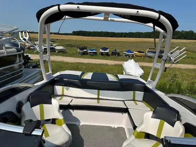 Slide: The Image of 2016 Four Winns H180 boat interior with seating, parked outdoors. - 17