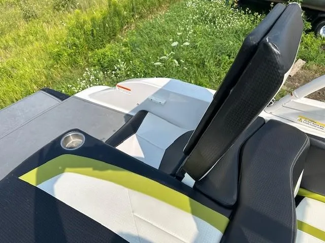 Slide: The Image of 2016 Four Winns H180 boat interior with black and white seating, cup holder, and green accents. - 4