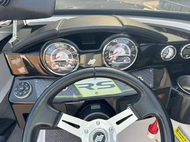 Slide: The Image of 2016 Four Winns H180 boat dashboard with steering wheel and gauges. - 9