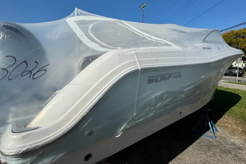 Slide: The Image of 2024 Sea Fox 226 Traveler boat covered in protective wrap, parked outdoors. - 3