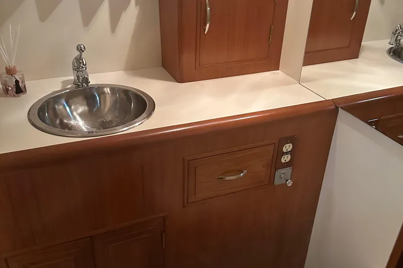 Slide: The Image of 1988 Ocean Alexander 42 aft cabin bathroom with wooden cabinetry and stainless steel sink. - 10