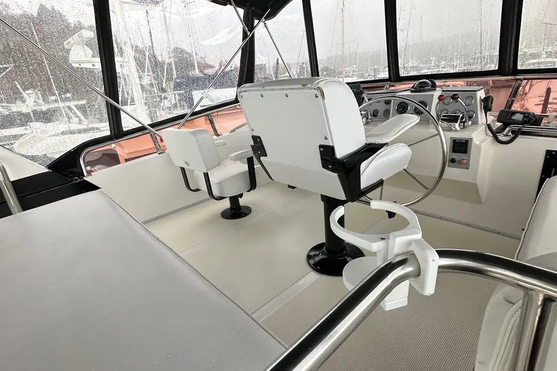 Slide: The Image of 1988 Ocean Alexander 42 aft cabin helm with white seating and steering wheel. - 2