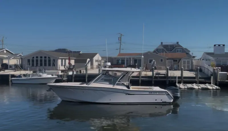 Slide: The Image of 2014 Grady-White Freedom 307 boat docked near waterfront homes. - 0