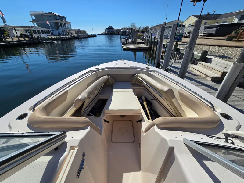 Slide: The Image of 2014 Grady-White Freedom 307 boat docked in a serene marina setting. - 10