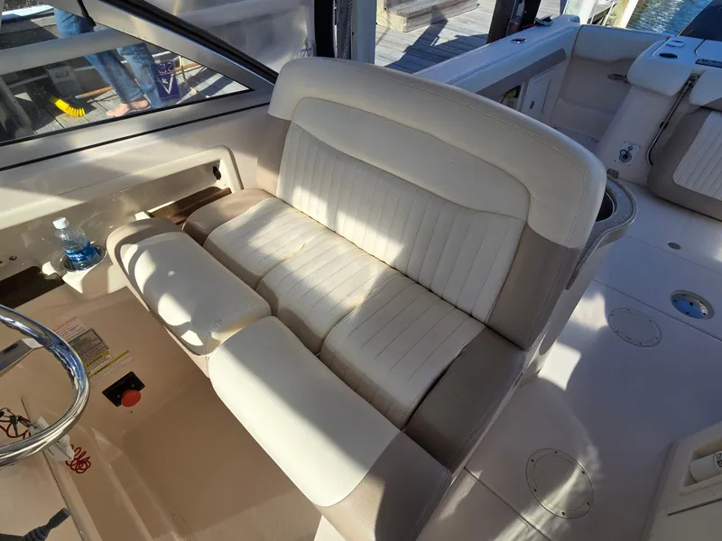 Slide: The Image of 2014 Grady-White Freedom 307 boat interior with white seating and steering wheel. - 12
