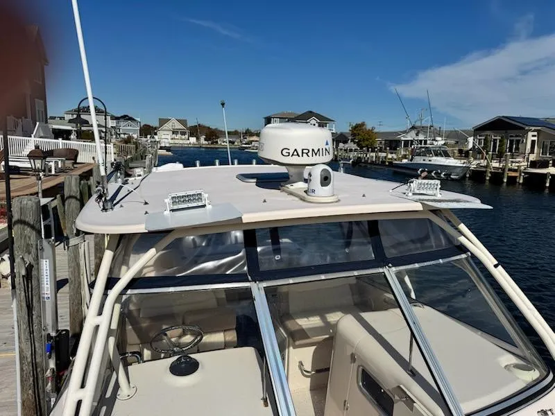Slide: The Image of 2014 Grady-White Freedom 307 boat docked, featuring Garmin equipment, in a scenic waterfront setting. - 16