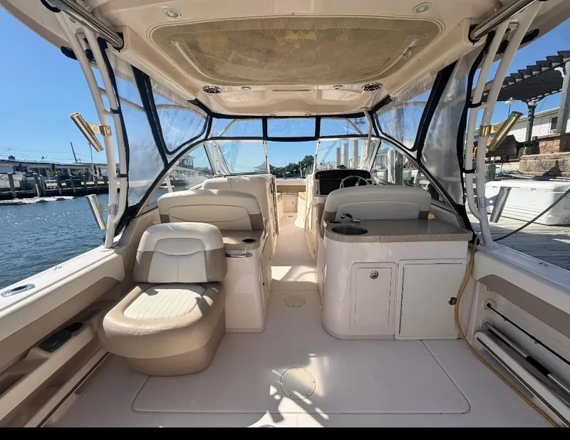 Slide: The Image of 2014 Grady-White Freedom 307 boat interior with seating and helm, docked by the water. - 19