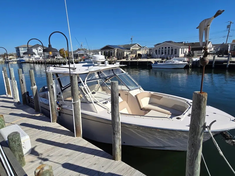 Slide: The Image of 2014 Grady-White Freedom 307 docked at a marina under clear blue skies. - 2