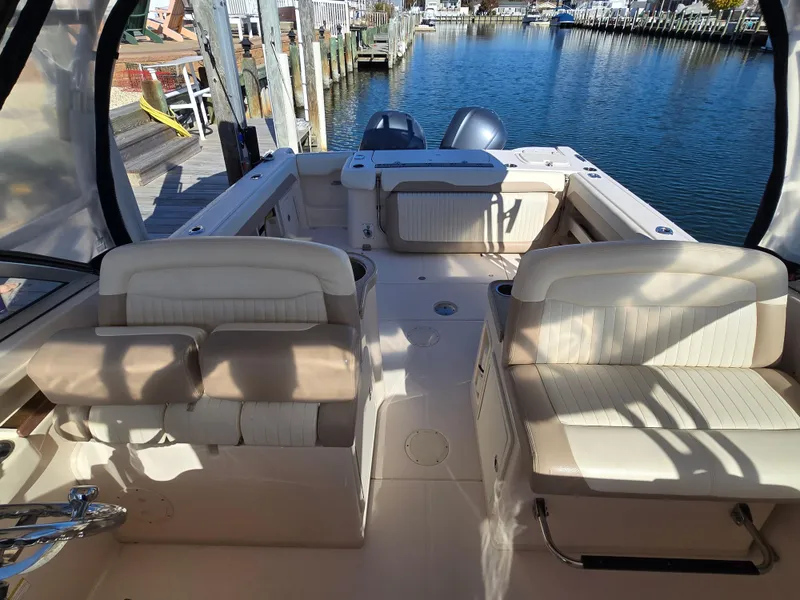 Slide: The Image of 2014 Grady-White Freedom 307 boat interior with seating, docked by the water. - 20