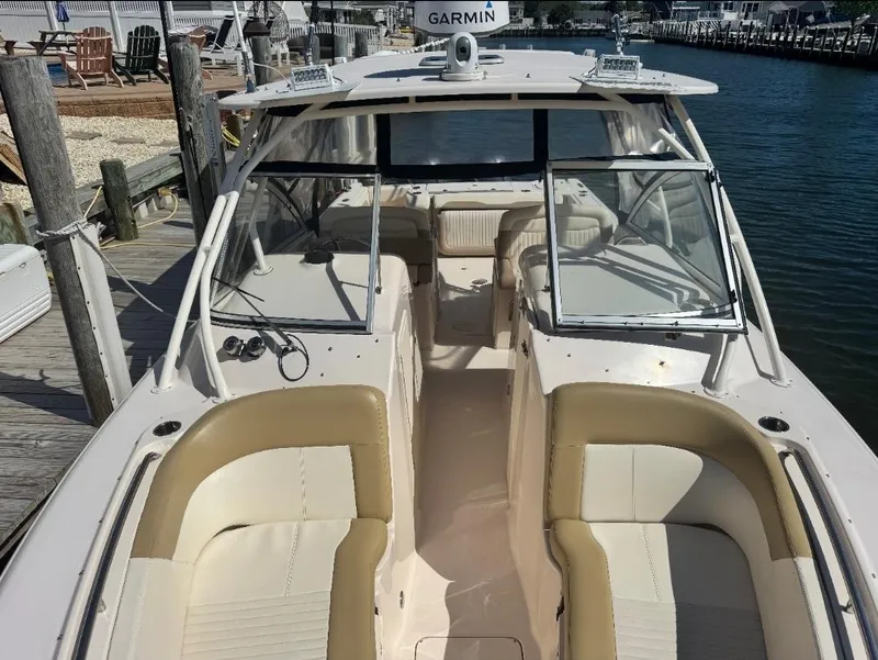 Slide: The Image of 2014 Grady-White Freedom 307 boat docked, featuring spacious seating and Garmin navigation. - 21