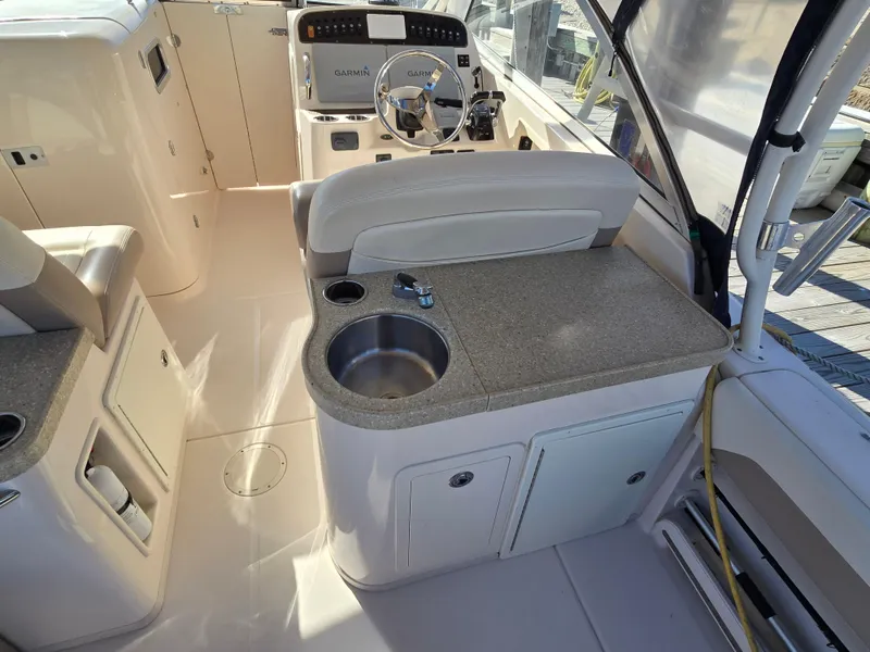 Slide: The Image of 2014 Grady-White Freedom 307 boat interior with helm and sink area. - 23