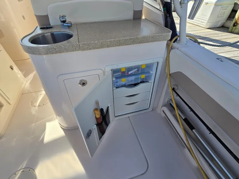 Slide: The Image of 2014 Grady-White Freedom 307 boat interior with sink and storage compartments. - 26