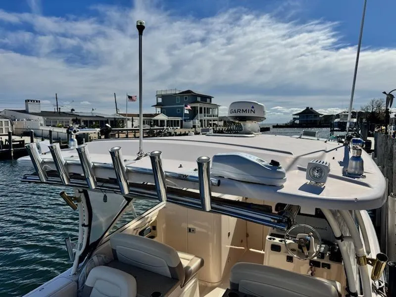 Slide: The Image of 2014 Grady-White Freedom 307 boat docked at marina under blue sky. - 34