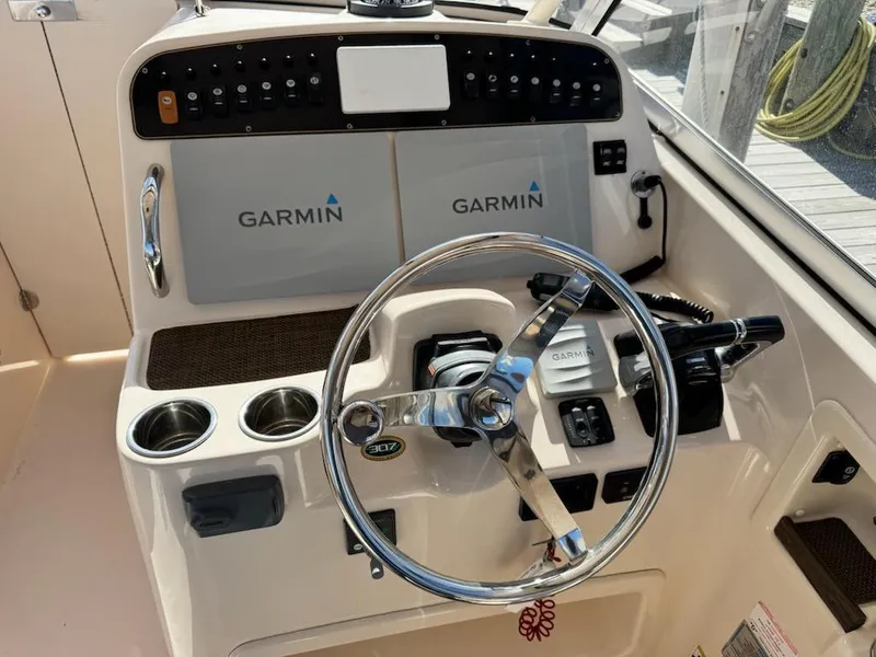 Slide: The Image of 2014 Grady-White Freedom 307 boat dashboard with Garmin navigation system and steering wheel. - 6