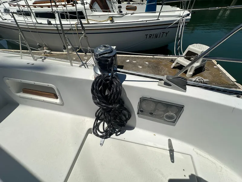Slide: The Image of Sailboat deck with coiled rope, Nonsuch Ultra 1986, docked near another boat named Trinity. - 15