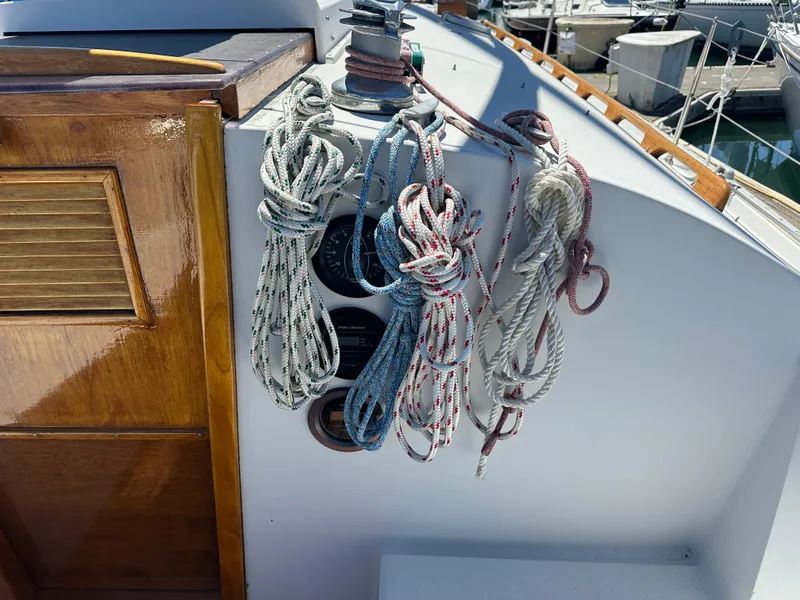 Slide: The Image of Coiled ropes on a 1986 Nonsuch Ultra sailboat deck near wooden hatch. - 16