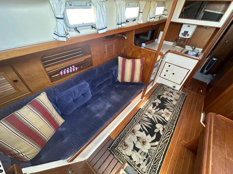Slide: The Image of Cozy 1986 Nonsuch Ultra yacht interior with blue sofa, striped cushions, and floral rug. - 5