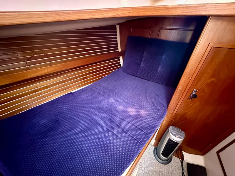 Slide: The Image of 1986 Nonsuch Ultra cabin with blue bedding and wooden interior. - 7