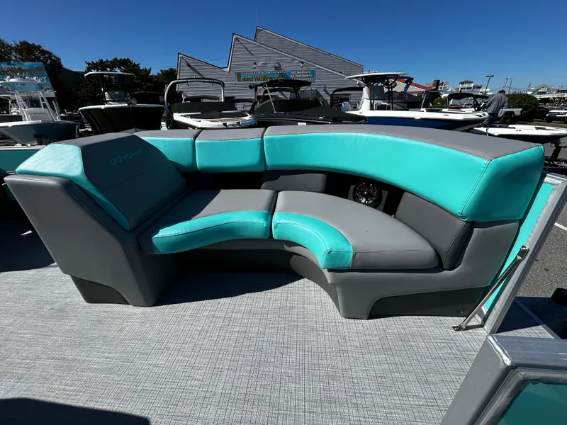 Slide: The Image of 2025 Berkshire 23RFX STS 3.0 boat with teal and gray seating at a marina. - 12