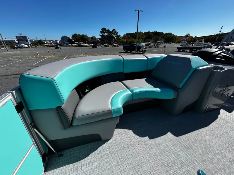 Slide: The Image of 2025 Berkshire 23RFX STS 3.0 boat with teal and gray seating in a parking lot. - 13