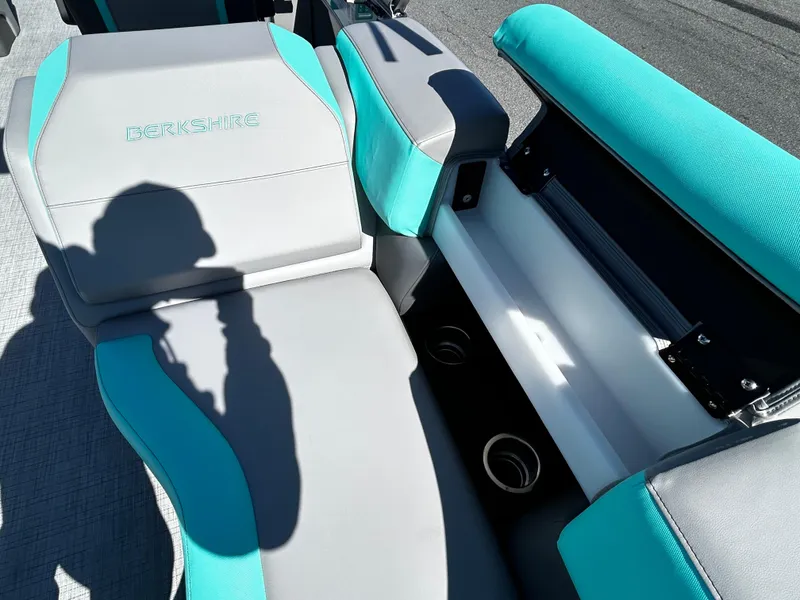 Slide: The Image of 2025 Berkshire 23RFX STS 3.0 boat interior with teal and gray seating and storage compartment. - 19